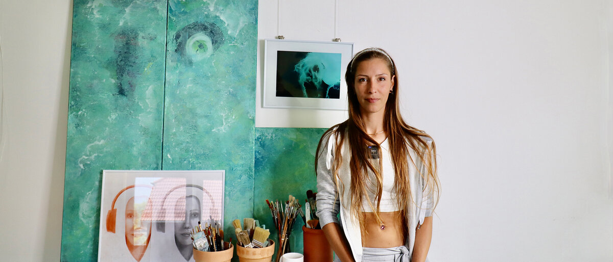 Die Künstlerin Abby McRey steht vor ihren Kunstwerken