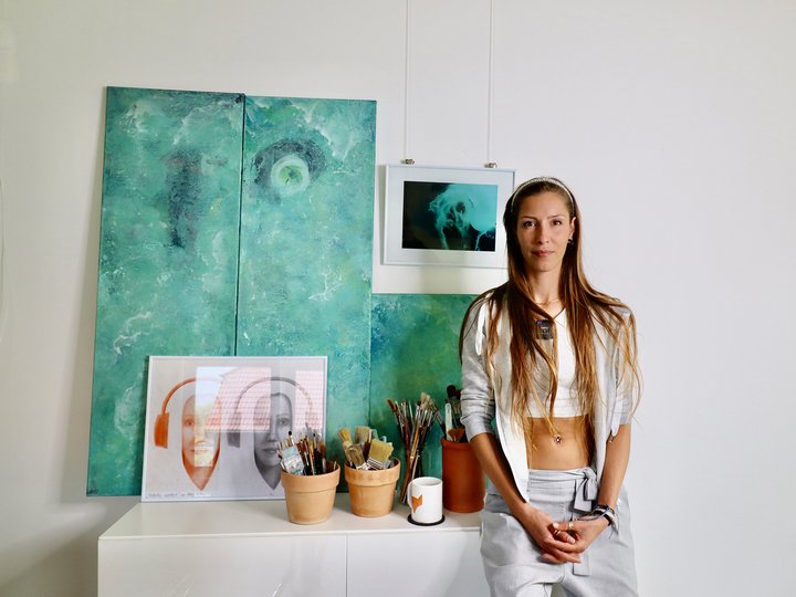 Die Künstlerin Abby McRey steht vor ihren Kunstwerken