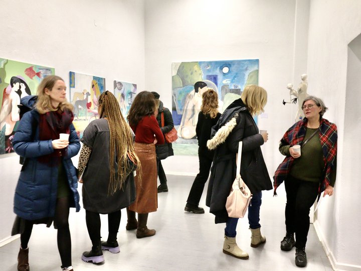 Besucher einer Vernissage schauen sich die Kunstwerke an.