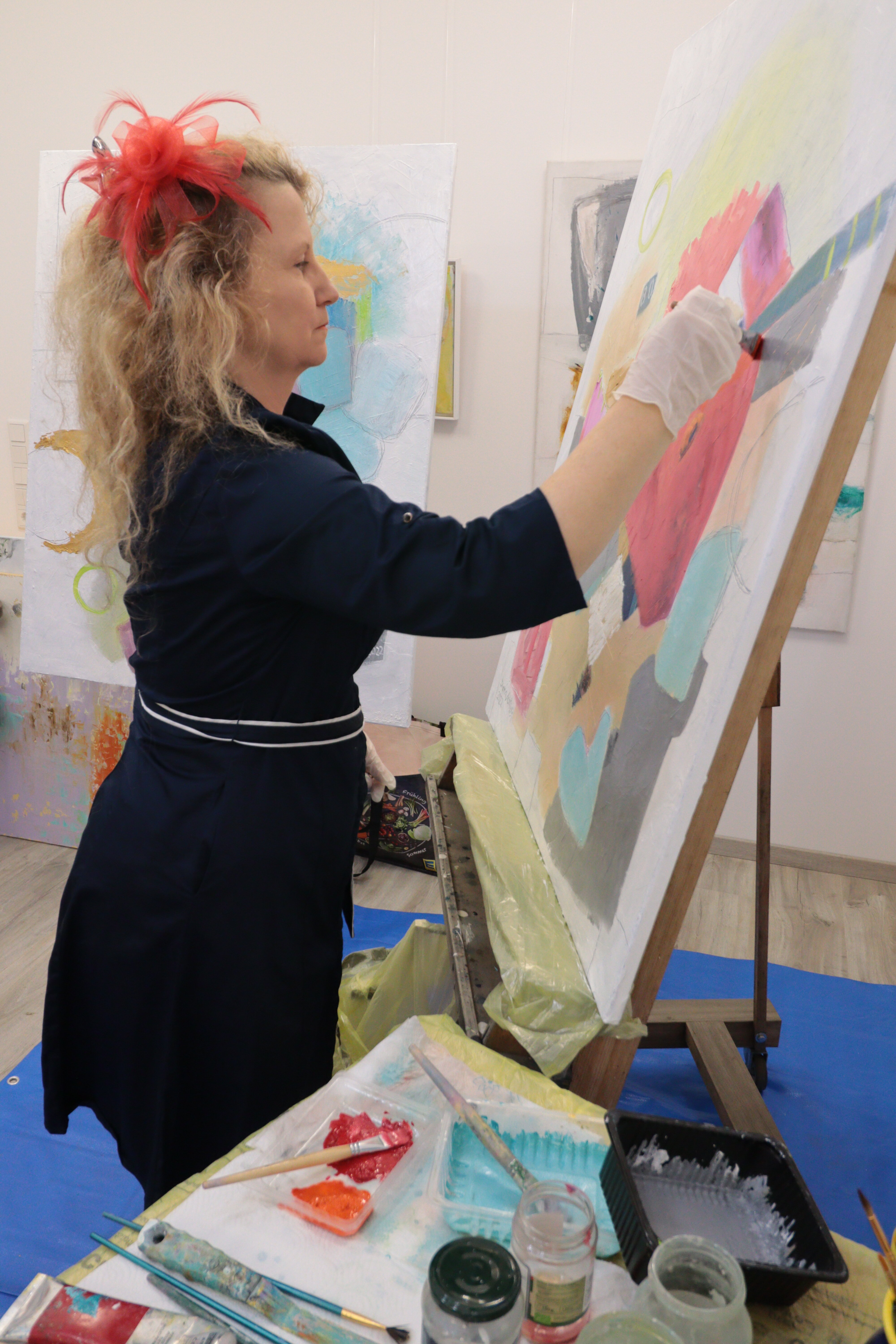 Diana Achtzig steht an ihrer Staffelei und mal zeitgenössische Wandbilder